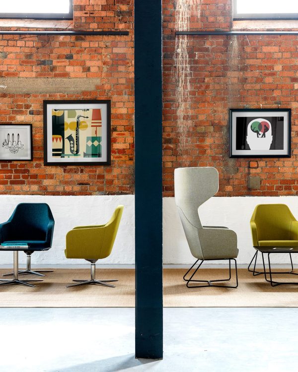 A group of lounge chairs for offices in a room with a brick wall.