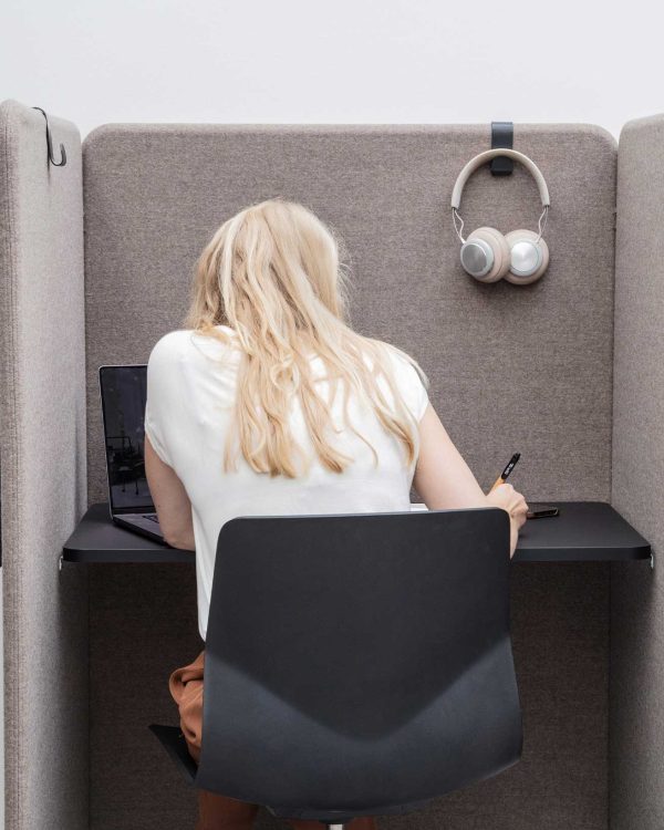 A woman sitting at a desk in a study booth