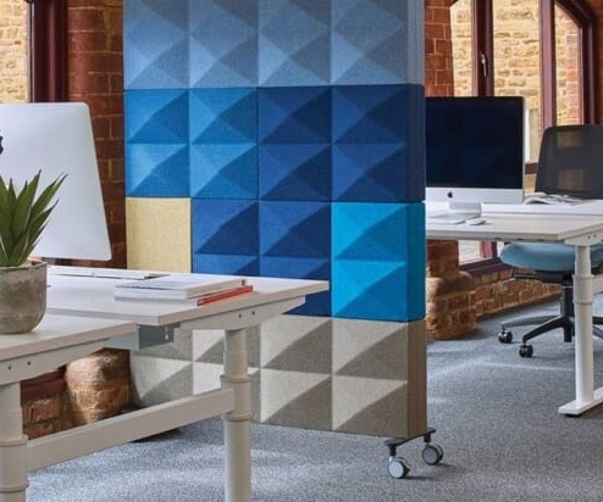 An office with blue and white desks and chairs and acoustic panels for offices