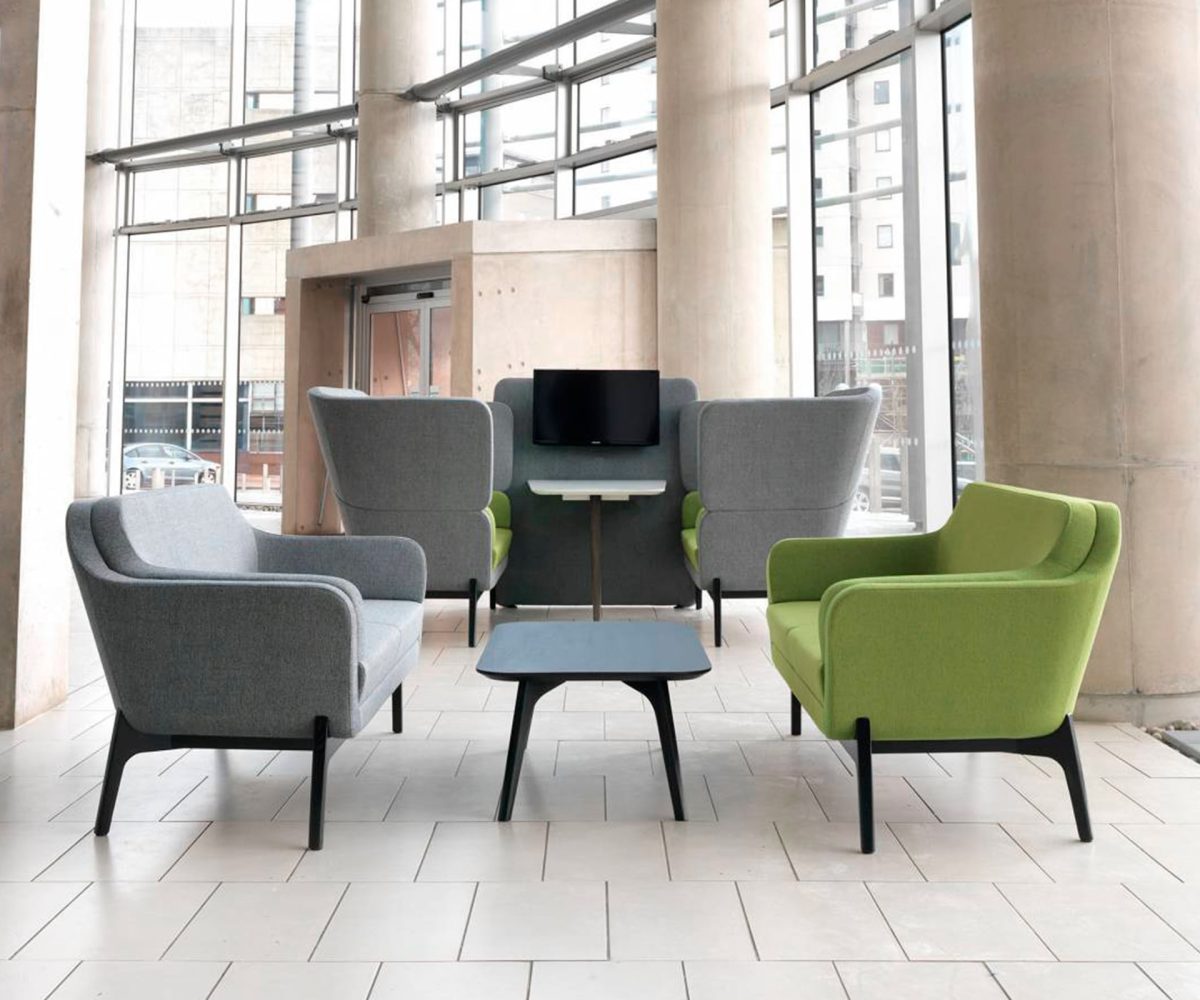 A group of lounge chairs for offices in a lobby with large windows.