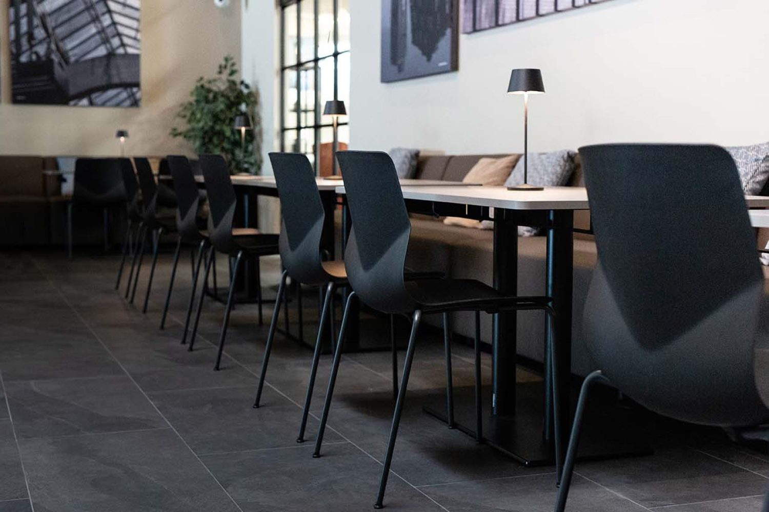 Canteen furniture including a long table and black chairs.