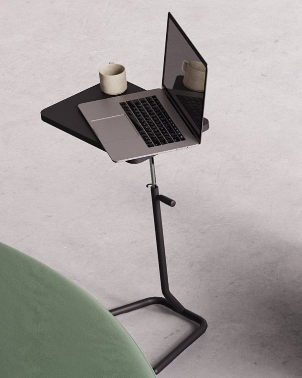 A laptop on an Y-table adjustable height work table next to a green couch.